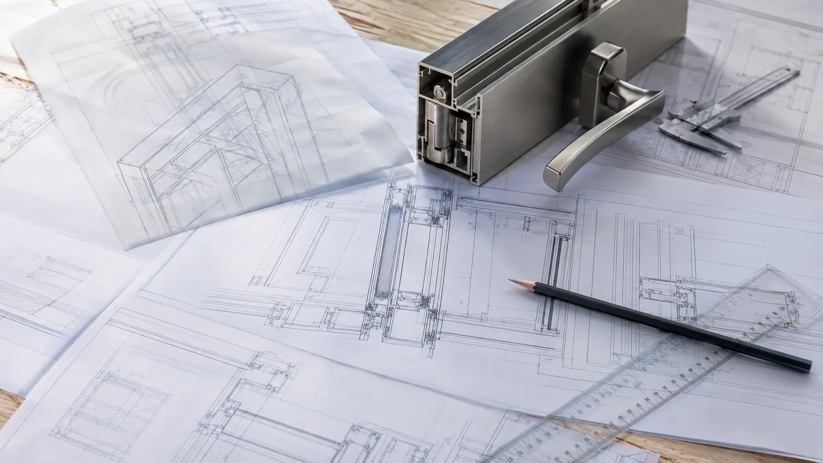 Architectural hardware technical drawings reviewed beside an aluminium profile
